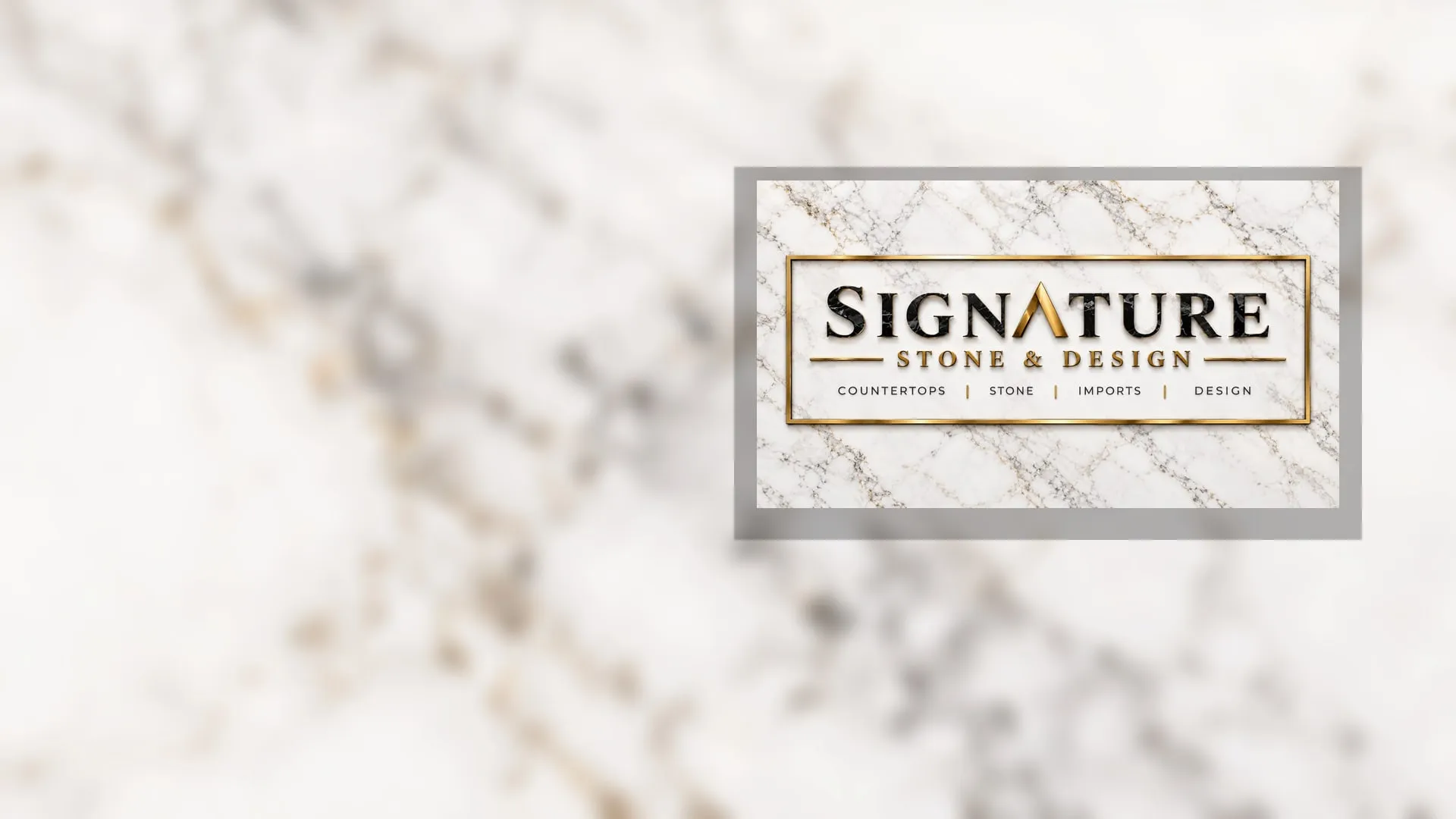 Signature Stone & Design sign in black marble and gold on a white marble wall